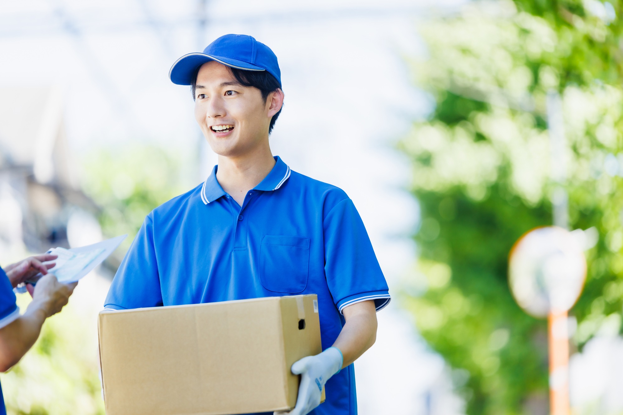 荷物を運ぶ青い作業着の男性スタッフのイメージ